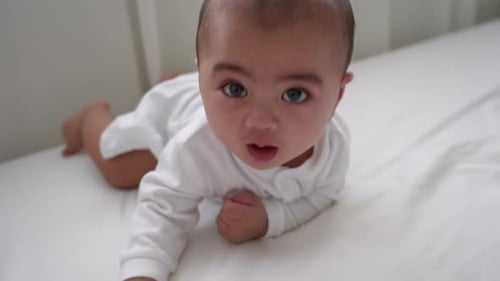 Infant Lying on Stomach Looks Around