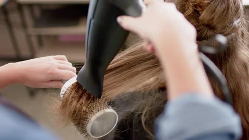 Stylist Dries Hair with Brush, Close-up Hairdressing