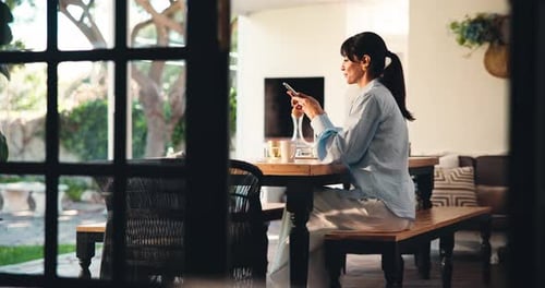 Woman Using Phone While Drinking Coffee at Home