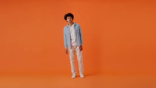 Ein Herr winkt mit der Hand und macht eine Hallo-Geste im Studio