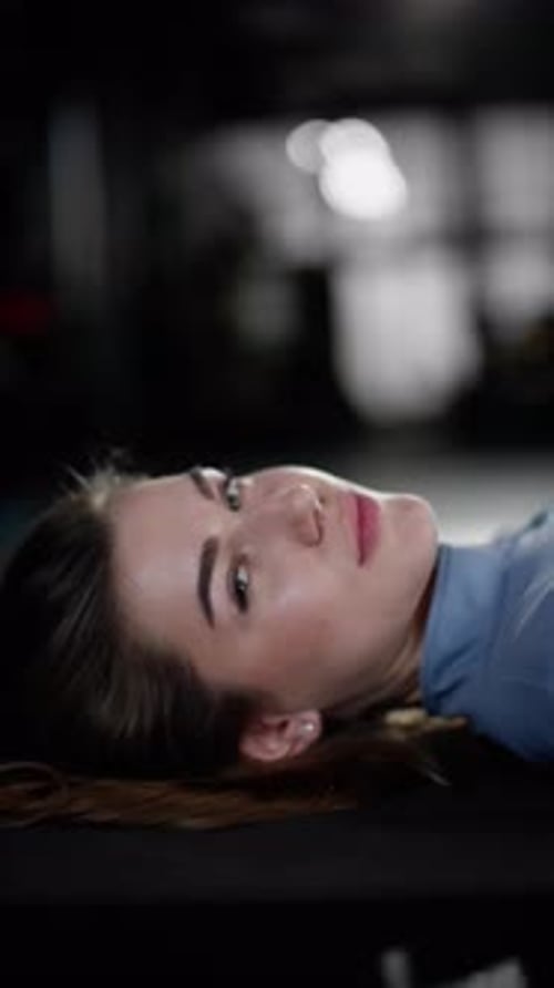 Athletic Woman Resting on a Gym Mat Looking Up Contemplatively Moments of Serenity Between Workouts