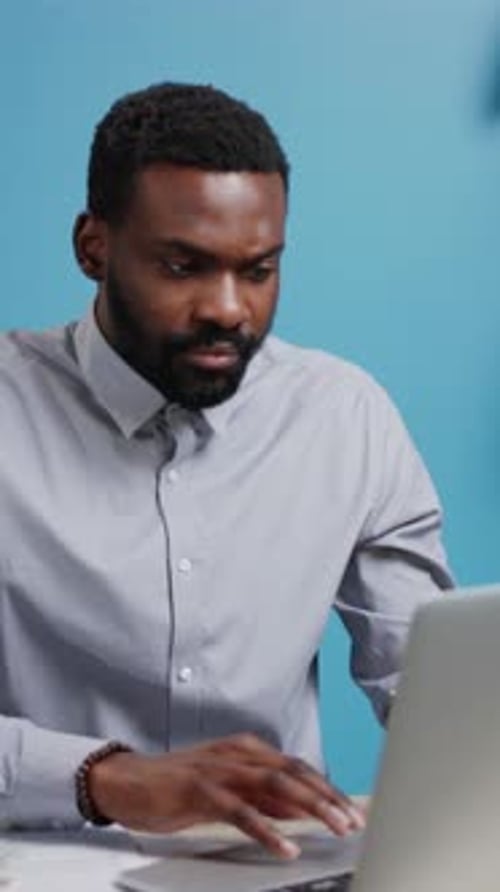 A Focused Professional Working Diligently on a Laptop at a Modern Workspace Environment