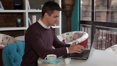 Mann benutzt Laptop im Café