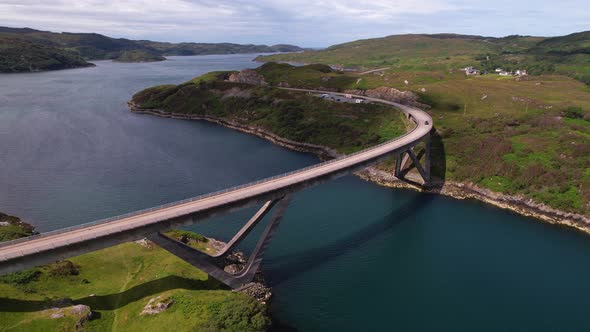 Curved Bridge Over a Scottish Loch Amid Stunning Green Hills and Calm ...