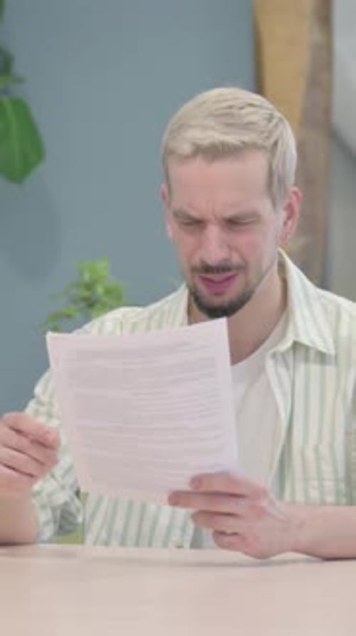 Modern Young Man Feeling Upset after Reading Documents, Paperwork