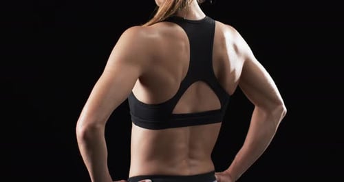 Athletic Woman Posing After Workout on Black Background