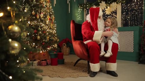 Girl on Santa's Lap Receives Christmas Gift