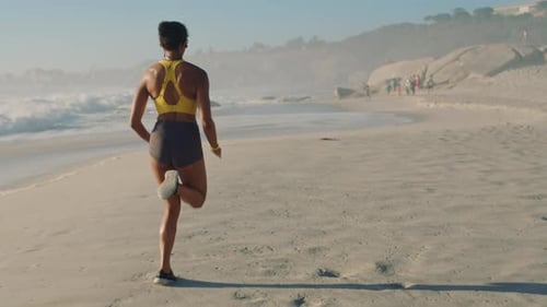 Sporty, active and fit woman running, jogging or exercising for fitness on the beach and seashore