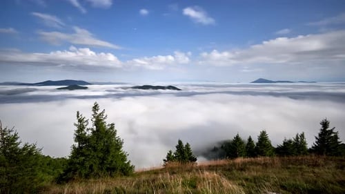 Moonlight Illuminating Clouds Over Misty Mountain Landscape in Night Timelapse