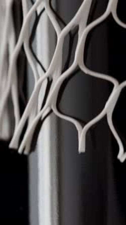 Hand Attaching White Netting to Silver Pole
