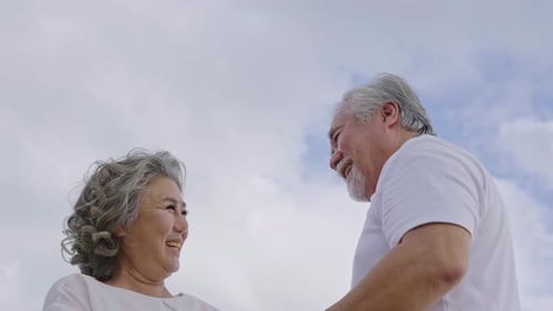 Loving Senior Couple Holding Hands at the Beach