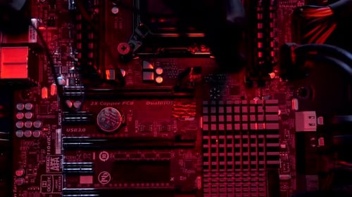 Inside View Of Computer Motherboard Seeing Heatsinks, Capacitors, DIMM and PCI Slot With RGB Lightin