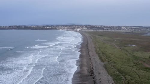 Dawn aerial: Waves break on to Tramore Strand beach in south Ireland