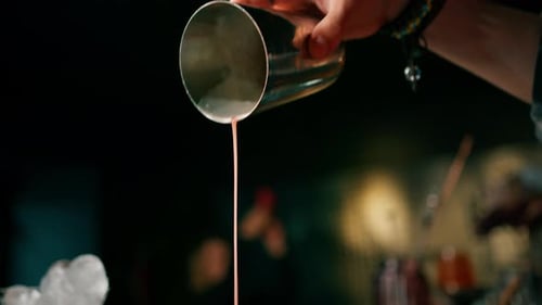 The process of making a cocktail in a bar A bartender mixes the ingredients of an alcoholic cocktail