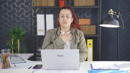 Woman Coughing at Desk in Office