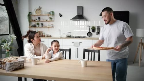 Family Enjoying Homemade Pizza in Modern Kitchen