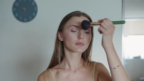 Woman Applies Makeup with Brush at Home