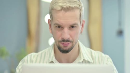 Close Up of Young Man Reacting to Loss on Laptop