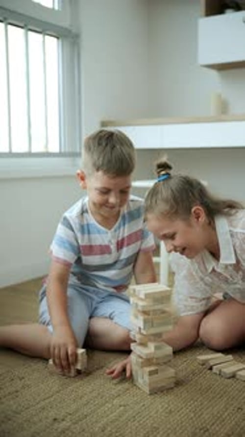 Children Caucasians Schoolchildren Play Jenga in the Room Vertical Video