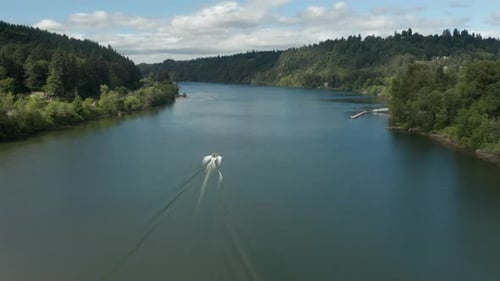 aerial dolly to orbit of a boat moving down the willamette river in oregon.