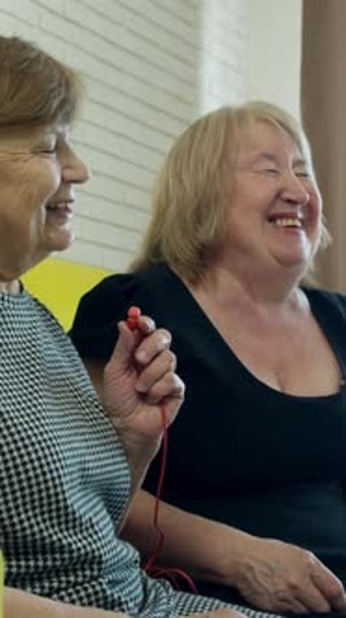 Senior Women Enjoying Music Together with Earphones