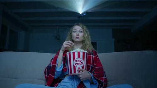 Woman Watches Movie Projector at Home at Night