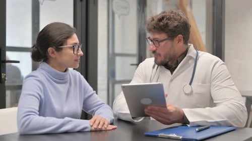 Doctor Discusses Information With Patient Using Tablet