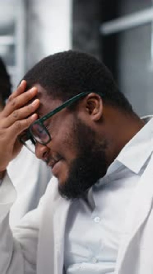 Doctor at Computer With Colleagues in the Background