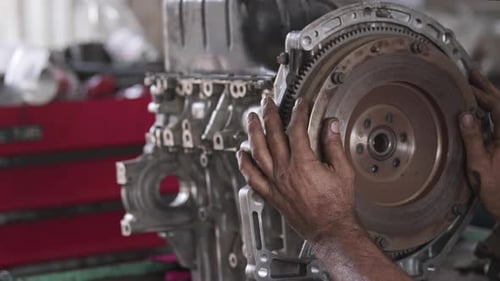 Master Repairing Flywheel Gear Of Car Engine In Repair Shop