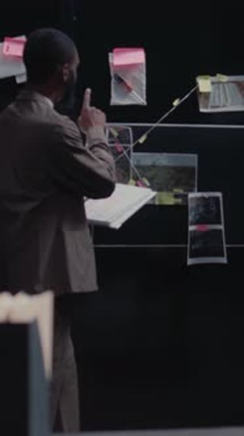 Man Investigating Crime Details in Dark Room