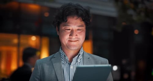 Man Using Tablet at Night in the City