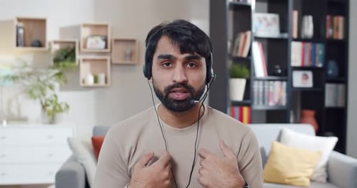 Man Wearing Headset Talking to Camera from Home