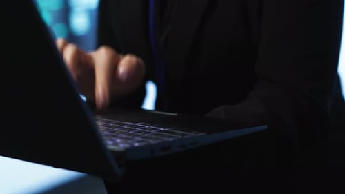 Programador no hub do servidor verificando o plano de recuperação no laptop de perto