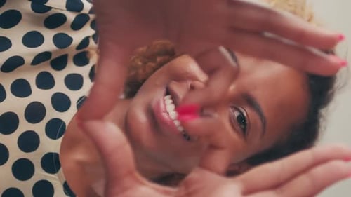 Smiling Woman Makes Heart Shape with Hands