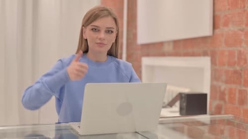 Woman Working on Laptop Gives Thumbs Up