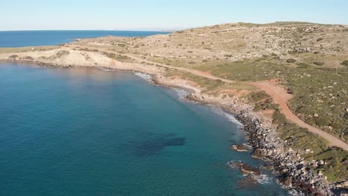 Aerial beautiful beach and water bay in the greek spectacular coast line. Turquoise blue transparent