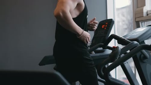 Muscular Male Athlete Exercising on Treadmills in the Modern Gym Doing Fitness Exercise