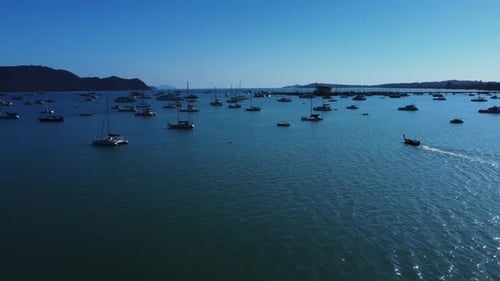 Im Seehafen neben dem Pier schwimmen viele Jachten und Boote, gefilmt mit Drohne