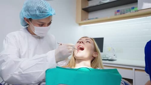 Female dentist examine tooth to Caucasian girl at dental health clinic.