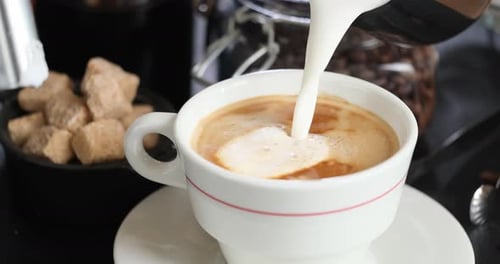 Milk Being Poured into Cup of Coffee