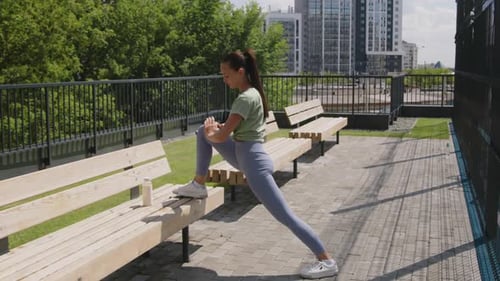 Athletic Woman Stretching on Park Bench