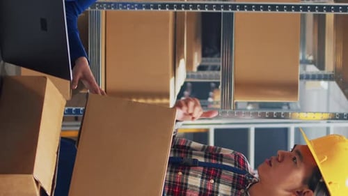 Warehouse Worker Receiving Box from Colleague