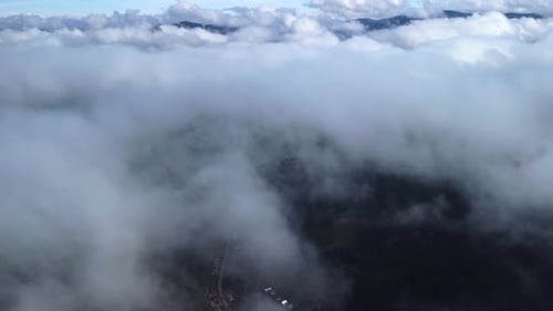 Dramatic Aerial of Mountains and Clouds in Rural Valley
