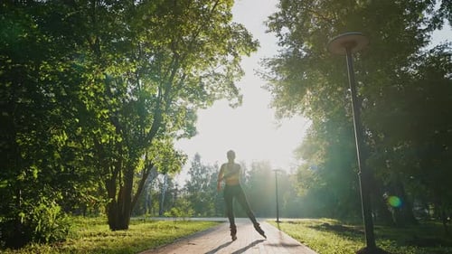 Skater Glides Through a Sunlit Park on a Beautiful Afternoon in Spring