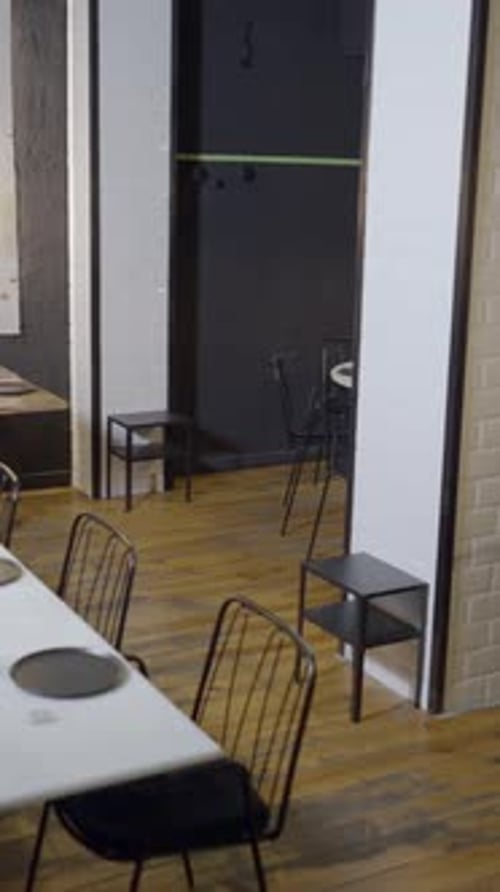 Pan of Interior of Modern Restaurant Where Owner Sits Alone at Table