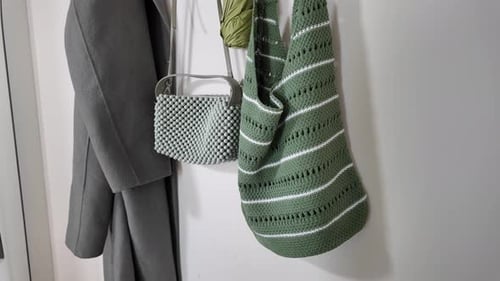 Bolsos y abrigos elegantes para colgar en la pared en un espacio acogedor
