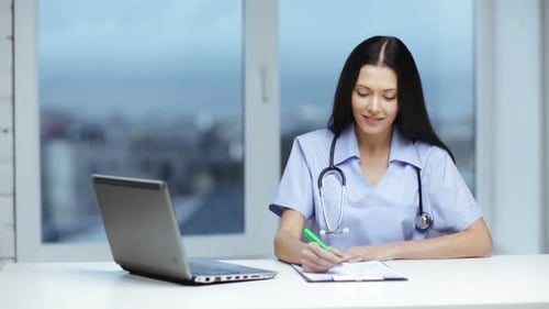 Friendly Doctor Prescribing with Laptop in Clinic