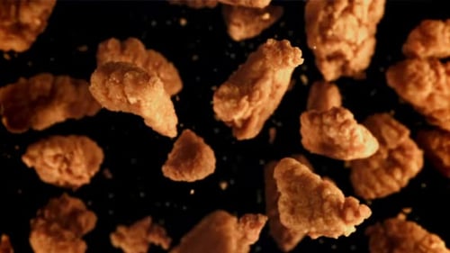Crispy Fried Chicken Pieces Falling on Black