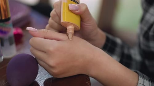 Closeup Partial View of Lady Applying Liquid Powder on Hand Using Sponge