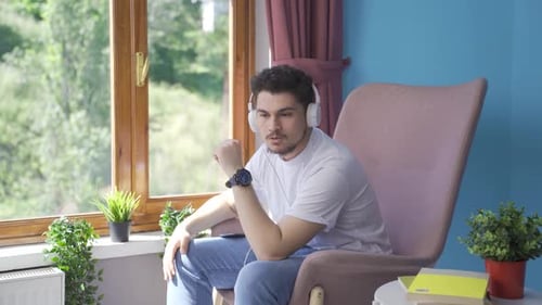 Man Listening to Music on Headphones, Relaxing Indoors